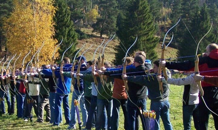 TeamBuilding - Intuitives Bogenschießen - Gruppe mit Pfeil und Bogen im Wald