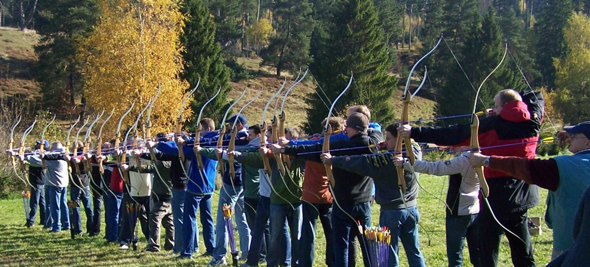 TeamBuilding - Intuitives Bogenschießen - Gruppe mit Pfeil und Bogen im Wald